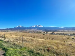 Two snow-capped Sangre de Cristo mountain peaks in the distance over the plains
