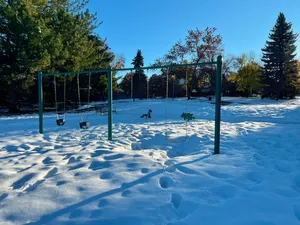 A snow-covered playground swing set