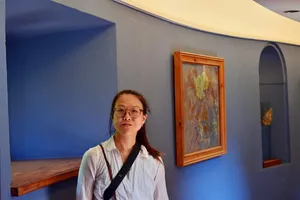 Woman in rounded blue corridor with art