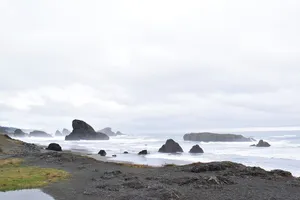 Rock formations along the shore on a cloudy day