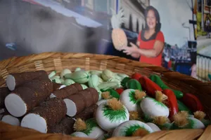 Fake vegetables in a basket in front of a cardboard cutout of a lady with a pineapple