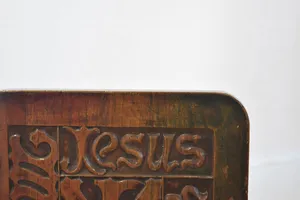 Corner of a wood engraving that says Jesus