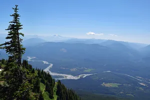 Evergreen above a winding creek in a valley and mountain layers